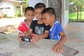 Three boys are watching the interest at a telephone.